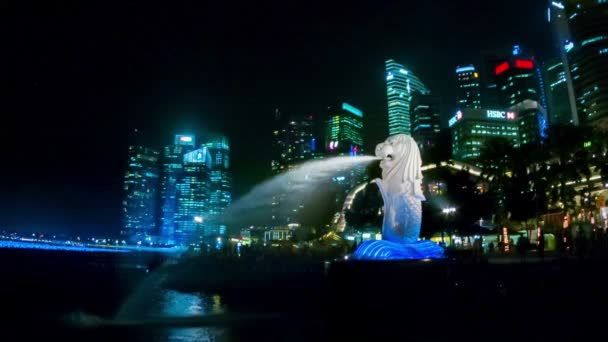 SINGAPORE - CIRCA DEC 2013: Symbol of the country - a lion with fish tail. A large statue with a fountain on the shore at night — Stock Video