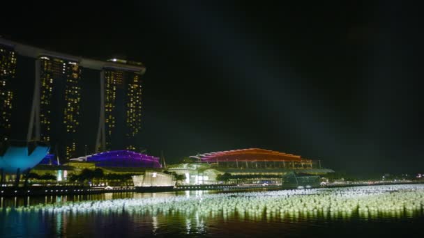 Singapore - circa dec 2013: nattvisning i viken. över den marina bay sands hotel och höga kontorsbyggnader — Stockvideo