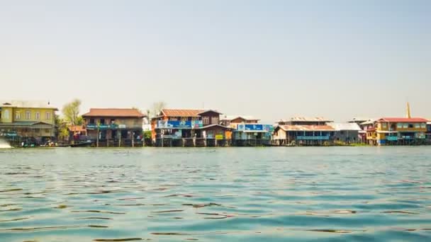 INLE LAKE, MYANMAR - CIRCA ENE 2014: Un pequeño pueblo sobre pilotes. Vista desde el barco en movimiento — Vídeo de stock