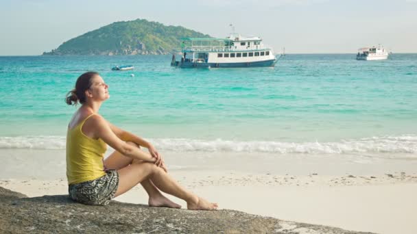 Відео 1080 р - дівчина сидить на скелі на березі моря. Сіміланскіе острови, Таїланд — стокове відео