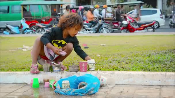 Phnom penh, Kamboçya - 29 Aralık 2013: karayolu trafiğe karşı kaldırımda bir çocuk çalış — Stok video