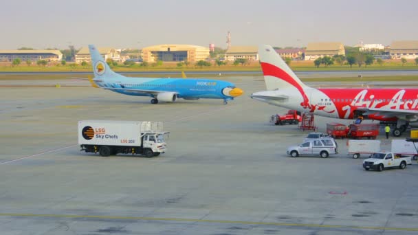 BANGKOK, TAILANDIA - 14 ENE 2014: Aviones de compañías Nok Air y Air Asia. Vista desde la ventana del aeropuerto — Vídeo de stock