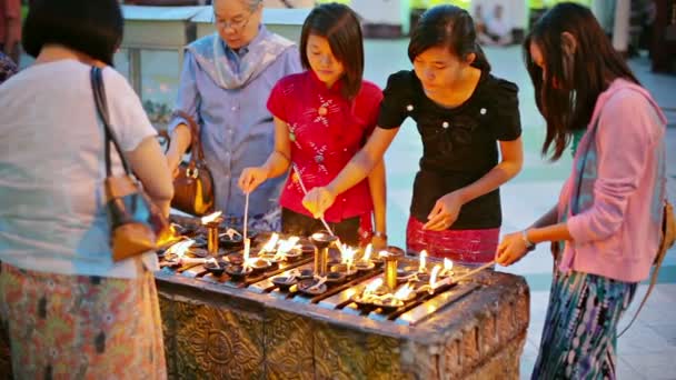 YANGON, MYANMAR - 03 ENE 2014: Las mujeres encendiendo lámparas de aceite - un ritual tradicional — Vídeos de Stock