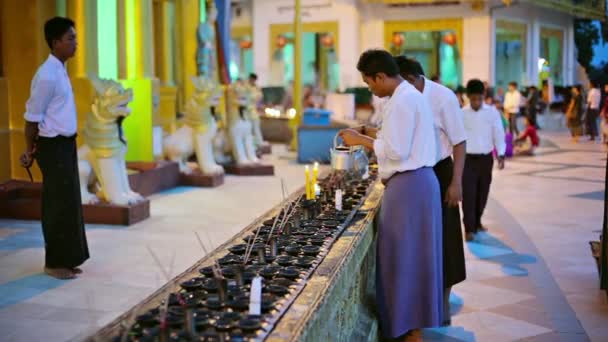 YANGON, MYANMAR - 03 JAN 2014: Temple workers prepare oil lamps for the evening ritual — Stock Video