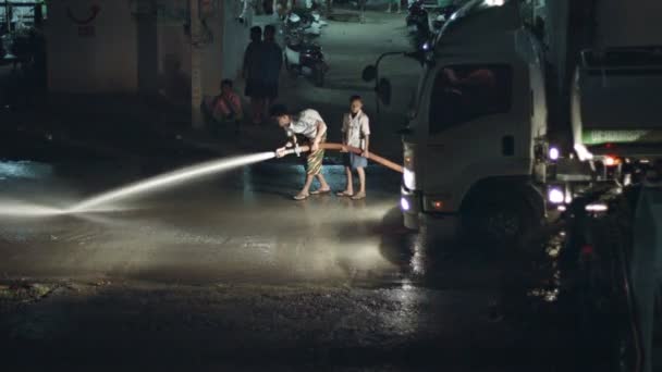 PHUKET, KAMALA, THAILAND - CIRCA AUG 2014: Locals wash asphalt on the highway with water — Stock Video