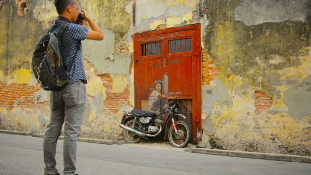 GEORGE TOWN, PENANG, MALASIA - 22 JUL 2014: Niño en bicicleta - pintura mural y turista con cámara — Vídeos de Stock