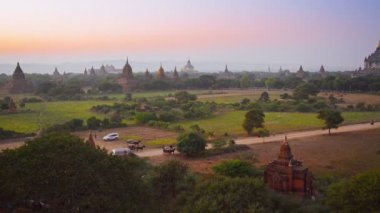 video 1080p - atlı arabaları turist oteller için gün batımında götürün. Burma, bagan