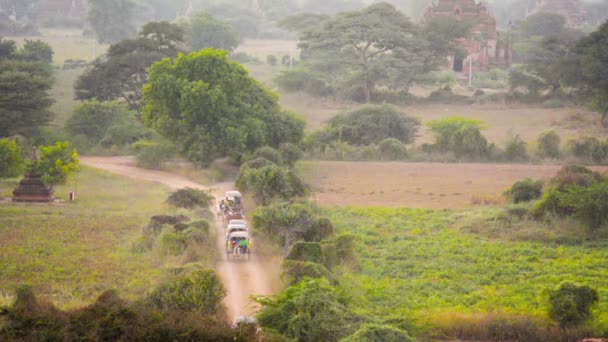 Vídeo 1920x1080 - Engarrafamento em uma estrada de terra. Carruagens de cavalos transportando turistas para hotéis. Myanmar, Bagan — Vídeo de Stock