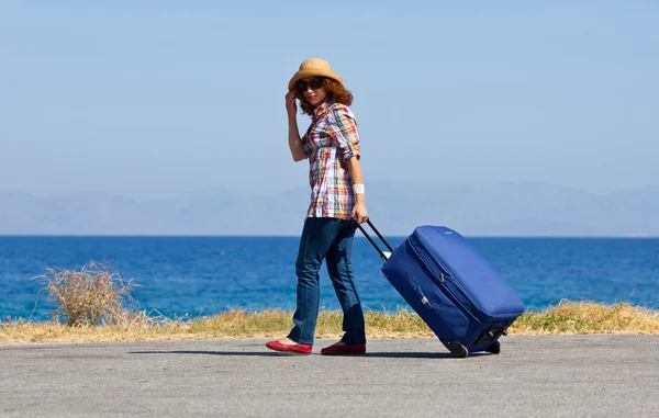 Attractive woman with suitcase on the beach — Stock Photo, Image