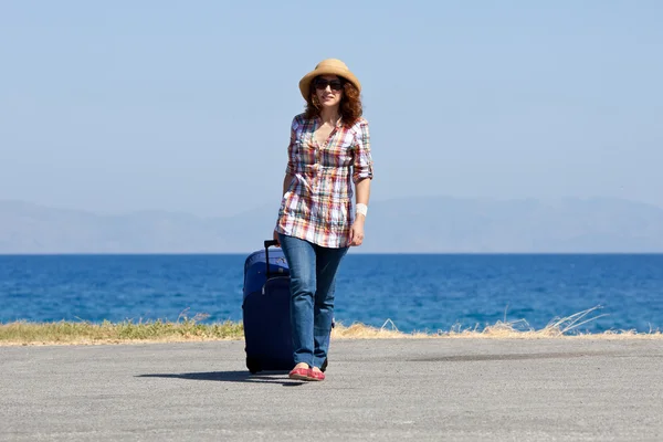 Attractive woman with suitcase on the beach — Stock Photo, Image