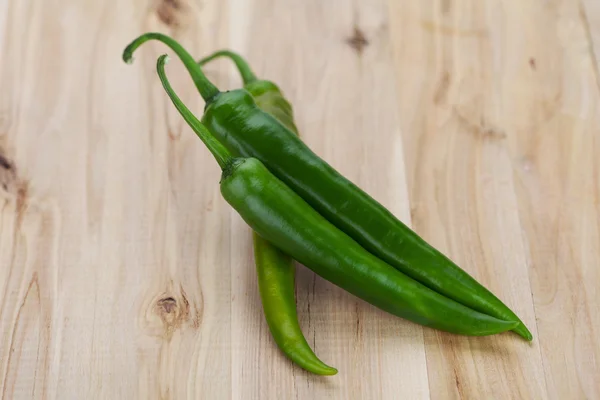 Chiles verdes sobre mesa de madera — Foto de Stock