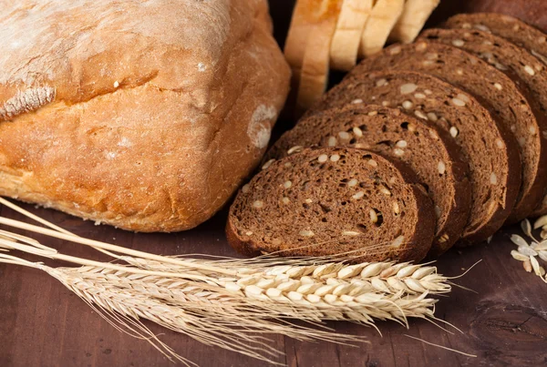 Vers brood en tarwe op het hout — Stockfoto