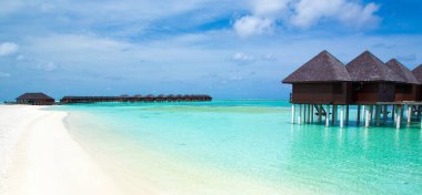 Plajı olan güzel tropik Maldivler adası. Su bungalovları olan deniz.