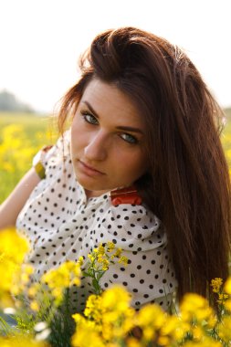 genç kıza tarlada sarı çiçekler kokuyor