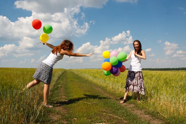 Gelukkig jonge vrouw en kleurrijke ballonnen — Stockfoto