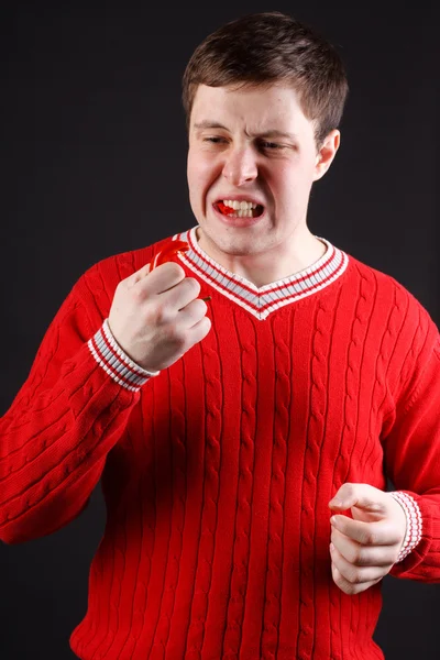 Young guy eats pepper — Stock Photo, Image