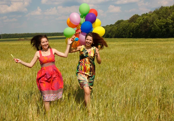 Gelukkig jonge vrouwen en kleurrijke ballonnen — Stockfoto