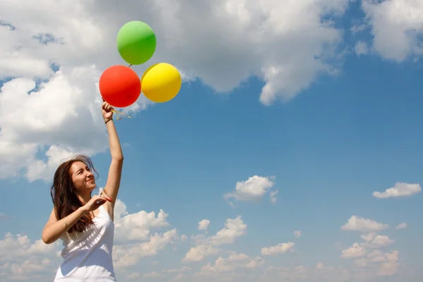 Szczęśliwa młoda kobieta i kolorowe balony — Zdjęcie stockowe