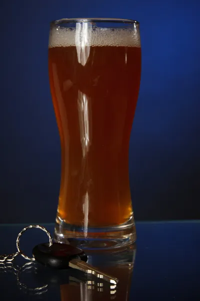 Car keys lying next to a full glass of beer — Stock Photo, Image