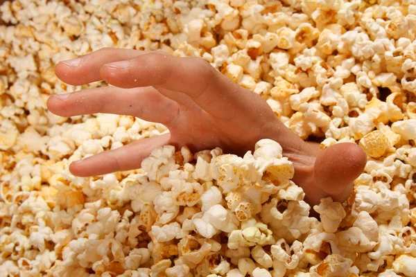 Hand kijkt uit popcorn — Stockfoto