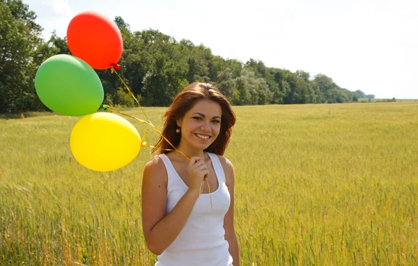 Szczęśliwa młoda kobieta i kolorowe balony — Zdjęcie stockowe