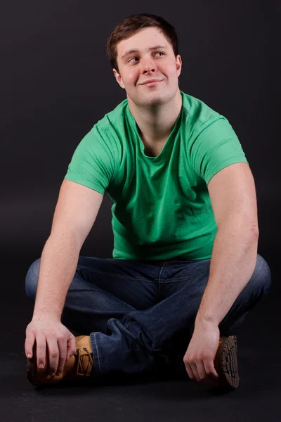 A young man sitting on the floor — Stock Photo, Image