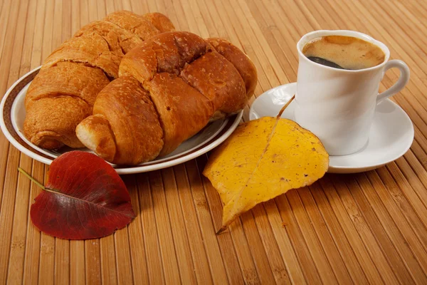 Scena d'autunno. Caffè e croissant sul tavolo — Foto Stock