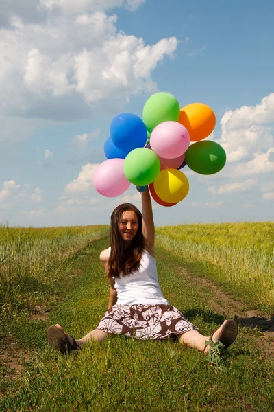 Mujer joven feliz y globos de colores — Foto de Stock