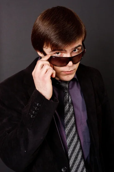 Handsome young business man standing on black background — Stock Photo, Image