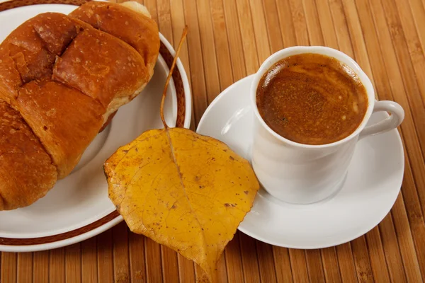 Scène d'automne. Café et croissant sur table — Photo