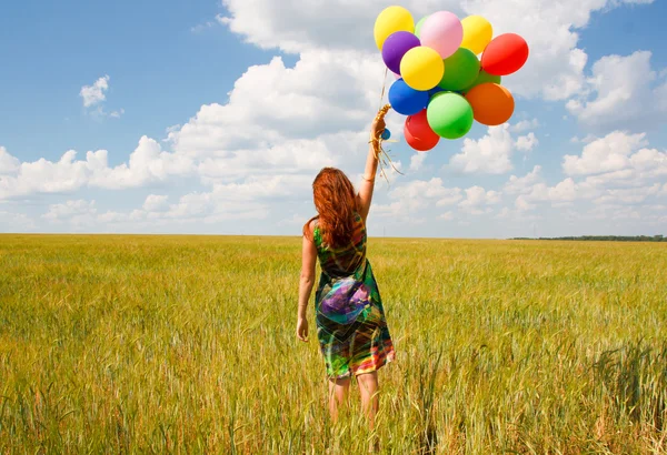 Mujer joven feliz y globos de colores — Foto de Stock