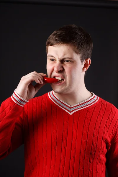 Genç adam yiyor biber — Stok fotoğraf