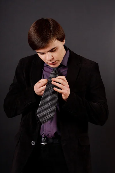 Handsome young business man standing on black background — Stock Photo, Image