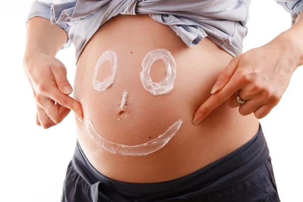 Buik een jonge zwangere vrouw met een smiley — Stockfoto