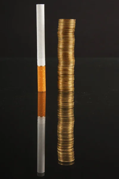 Стековые монеты и сигареты — стоковое фото