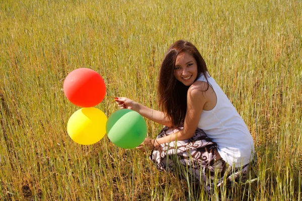 Šťastná mladá žena a barevné balónky — Stock fotografie