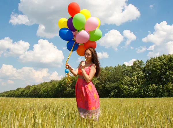 Gelukkig jonge vrouw en kleurrijke ballonnen — Stockfoto