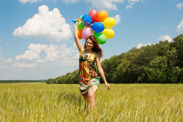 Mujer joven feliz y globos de colores — Foto de Stock