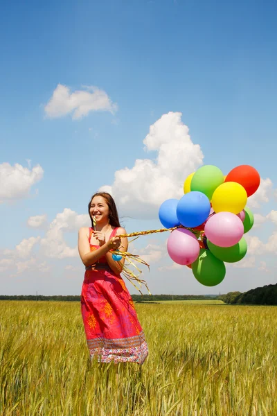 Счастливая молодая женщина и красочные воздушные шары — стоковое фото