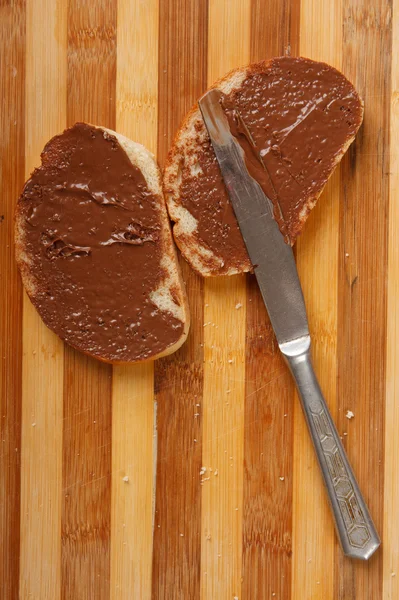 Pain avec tartinade au chocolat sur la table — Photo