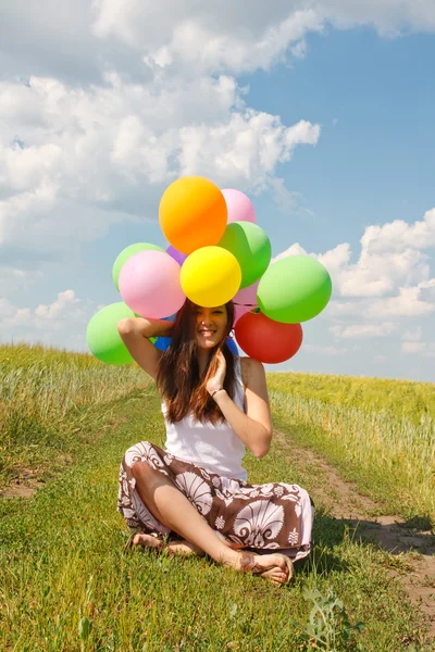 Szczęśliwa młoda kobieta i kolorowe balony — Zdjęcie stockowe