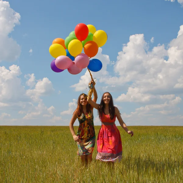 Jovens mulheres felizes e balões coloridos — Fotografia de Stock