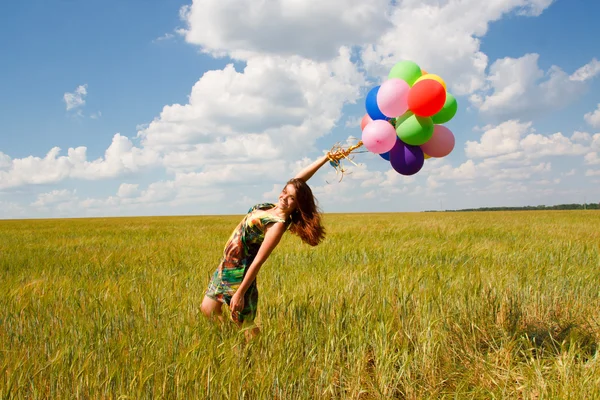 Mujer joven feliz y globos de colores — Foto de Stock