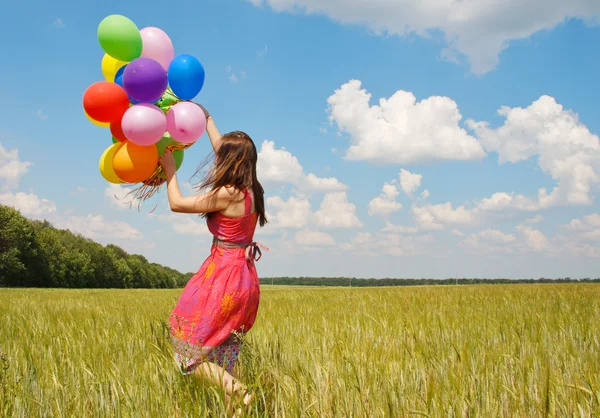 Gelukkig jonge vrouw en kleurrijke ballonnen — Stockfoto