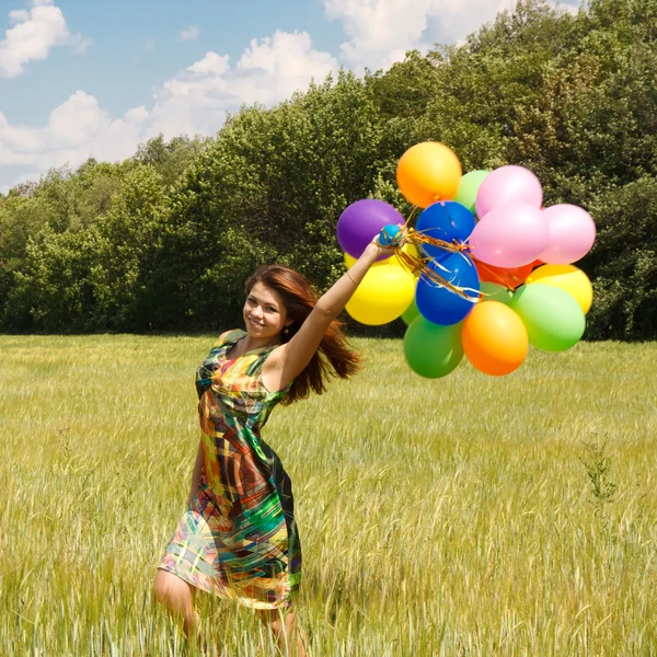 Jovem mulher feliz e balões coloridos — Fotografia de Stock