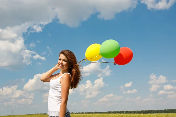 Šťastná mladá žena a barevné balónky — Stock fotografie