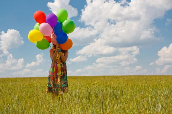 Glückliche junge Frau und bunte Luftballons — Stockfoto