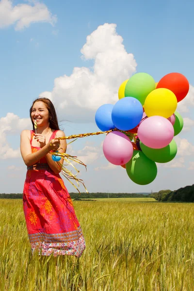 Gelukkig jonge vrouw en kleurrijke ballonnen — Stockfoto