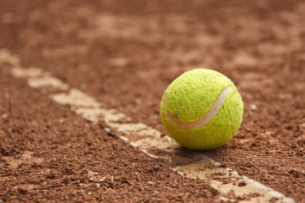 Tennis ball on a tennis clay court — Stock Photo, Image
