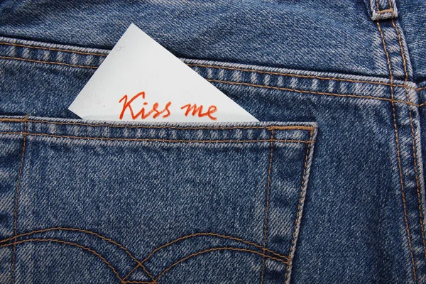 Sticker in your pocket jeans. The text - Kiss me. — Stock Photo, Image